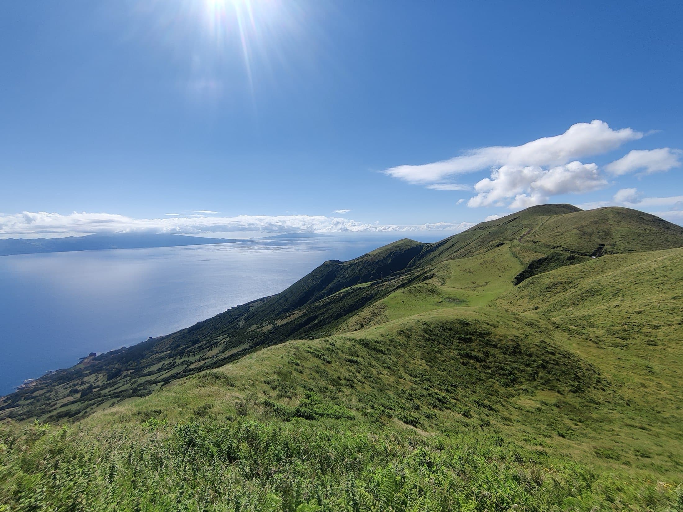 The green ridge of São Jorge falling to the Atlantic, Pico on the horizon